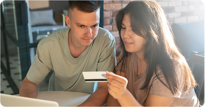 Two people shopping online with a card